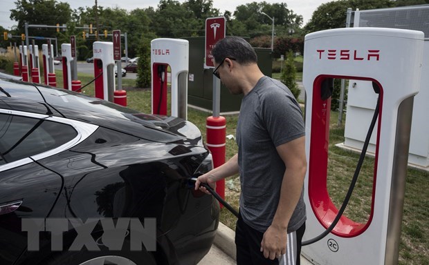 Người dân sạc điện cho ô tô tại một trạm sạc của Tesla ở Arlington, Virginia, Mỹ. (Ảnh: AFP/TTXVN)